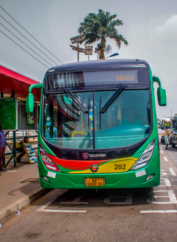 A green and red BRT bus operating in a city setting.